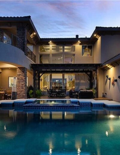A home with a pool and patio at dusk.