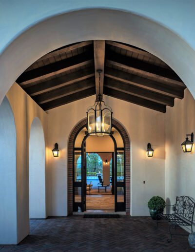 An archway leads to a hallway with light fixtures.