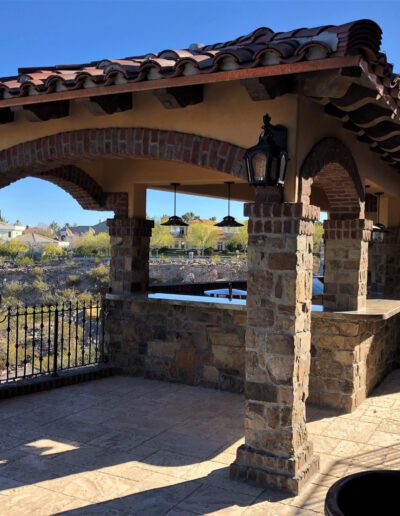 A patio with an outdoor kitchen and fireplace.