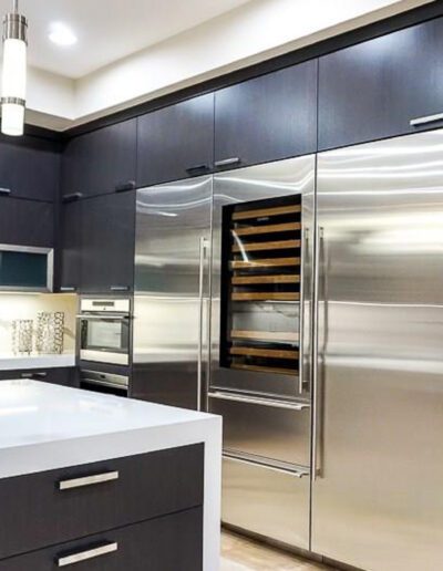 A modern kitchen with stainless steel appliances and black cabinets.
