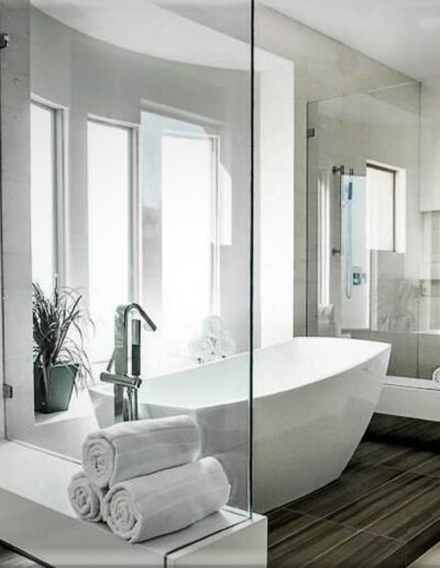 A white bathroom with a glass shower enclosure.