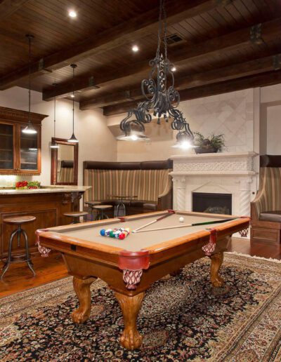 A room with a pool table and a fireplace.
