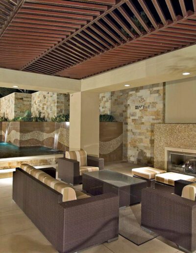 An outdoor living area with a fireplace and a pool.