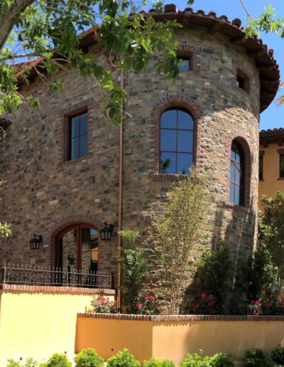 A stone house with a tree in front of it.