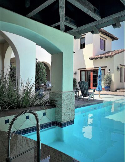 A swimming pool in the backyard of a house.