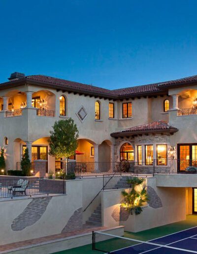 A mansion with a tennis court at night.