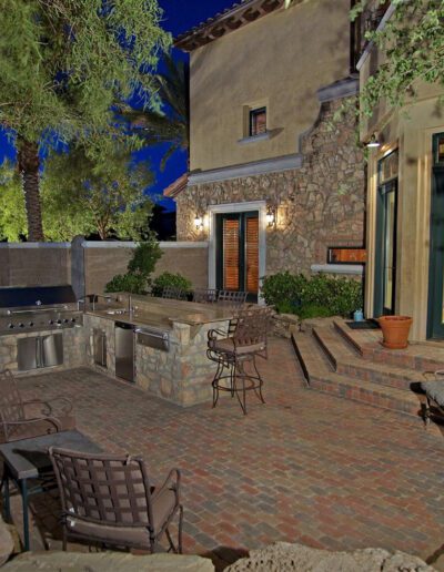 A patio with a grill and outdoor furniture.