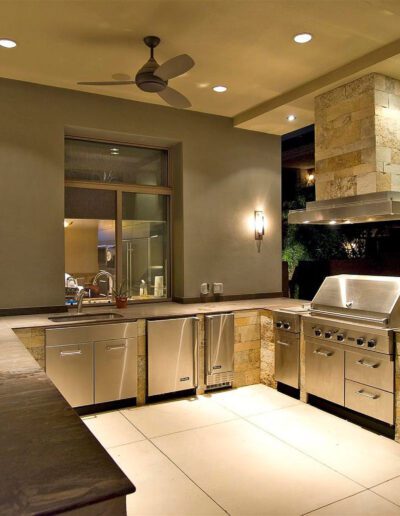 An outdoor kitchen with a stove and sink.