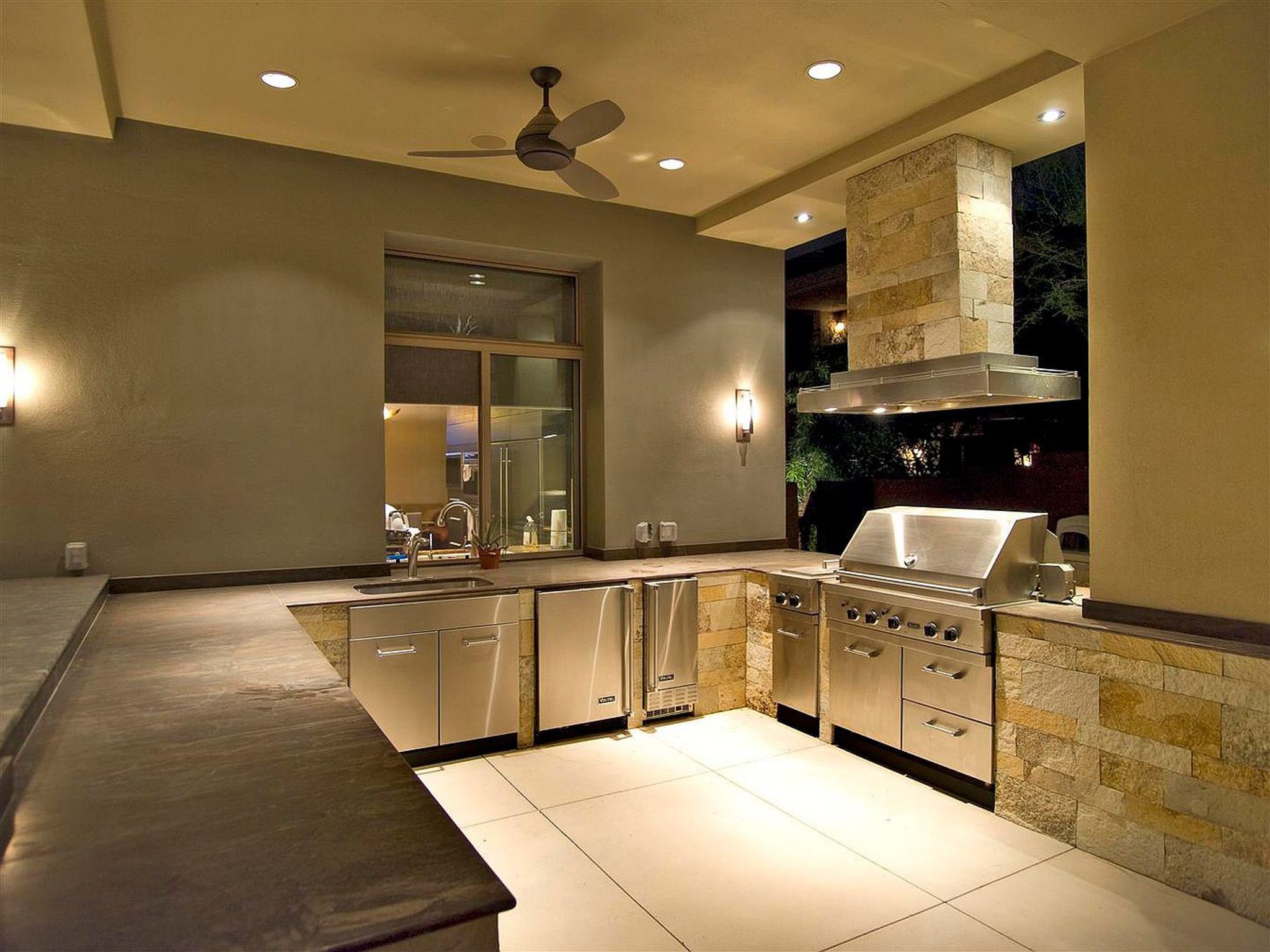 An outdoor kitchen with a stove and sink.