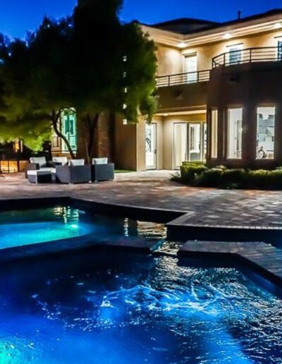 A home with a pool and patio at night.
