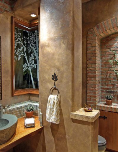 A bathroom with a brick wall and a sink.