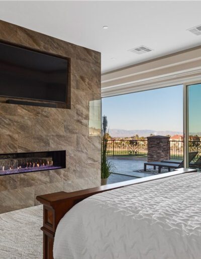 A bedroom with a fireplace and a view of the mountains.