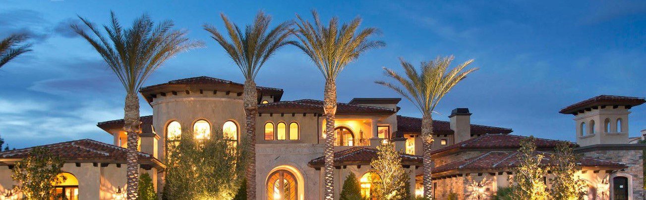 A large mediterranean style home with palm trees.