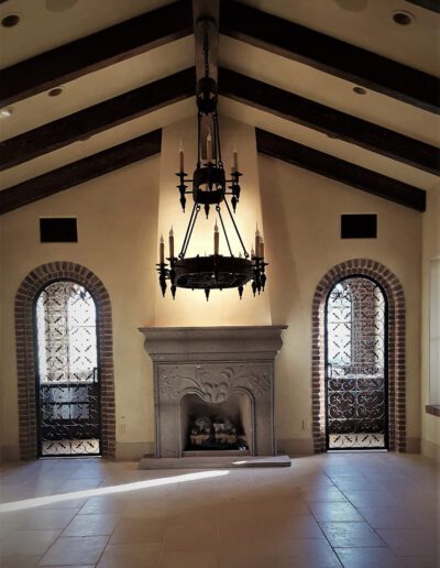 An empty room with a fireplace and chandelier.