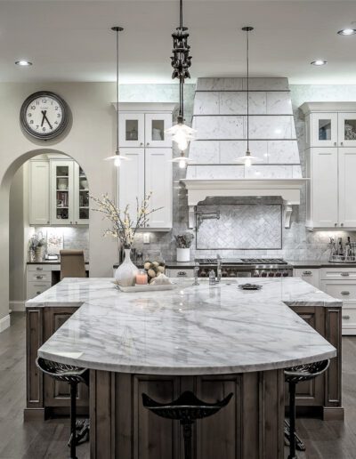 A large kitchen with white cabinets and marble counter tops.
